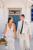 Bridal portraits in front of costal catholic church with boho bride in fringe dress and groom in light beige suit