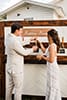 Boho bride and groom in front of custom beer tap wall