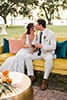 Boho bride and groom in colorful lounge area